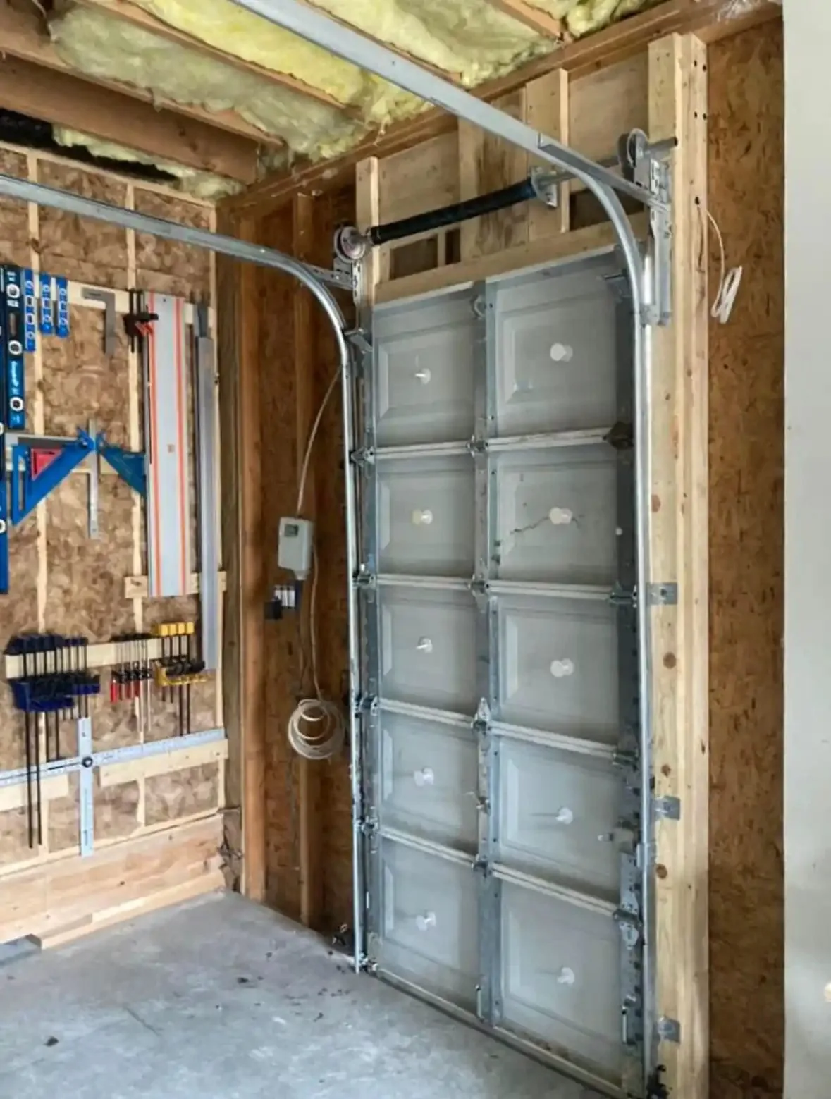 Interior garage door tracks and sectional panels