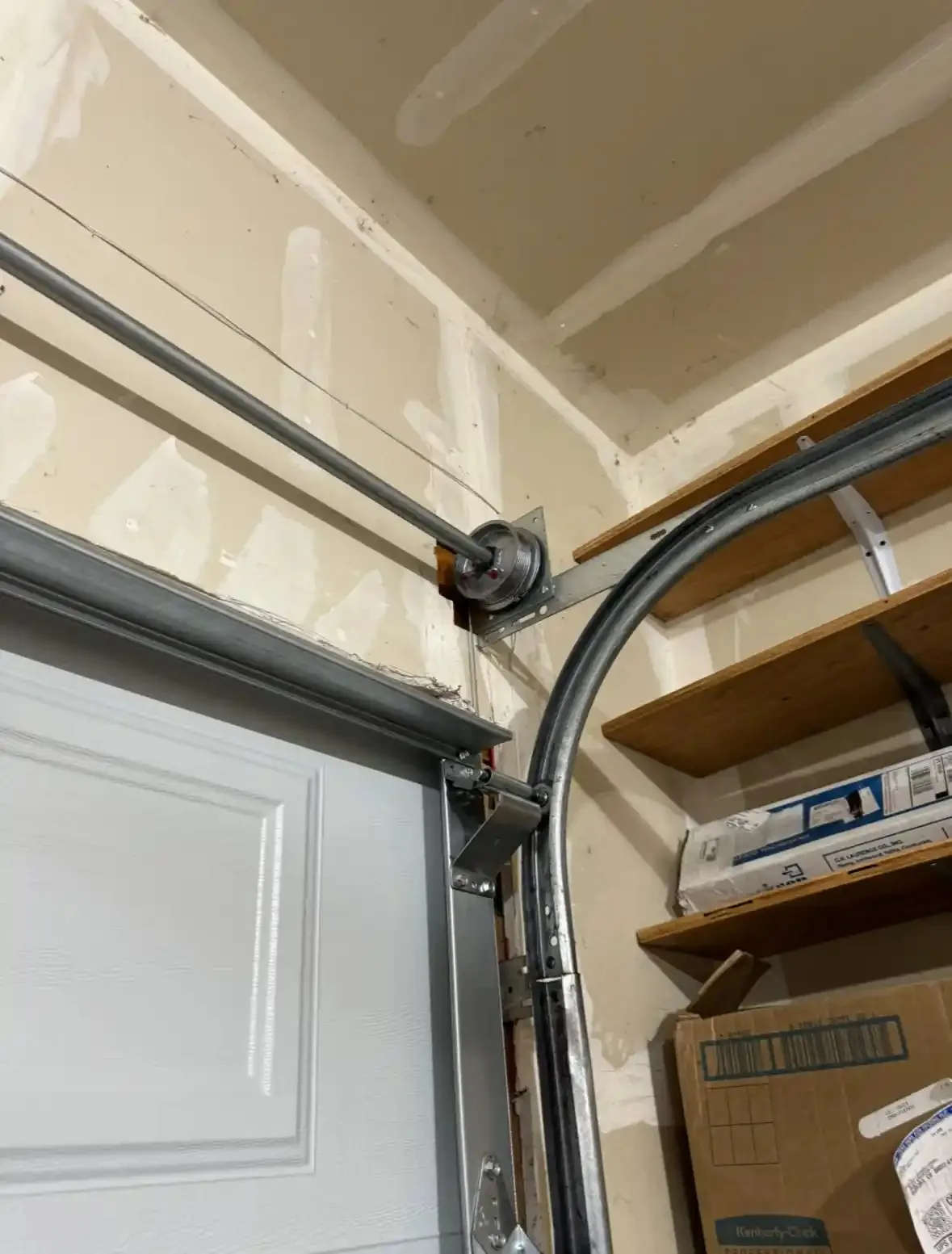 Cable drum and track above a sectional garage door